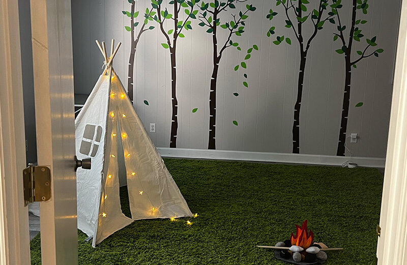 Play therapy room with toys and creative materials during a play therapy session. 
