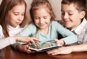 3 kids playing with an ipad
